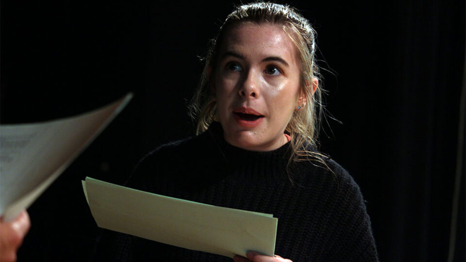 Photograph of a drama student reading a script