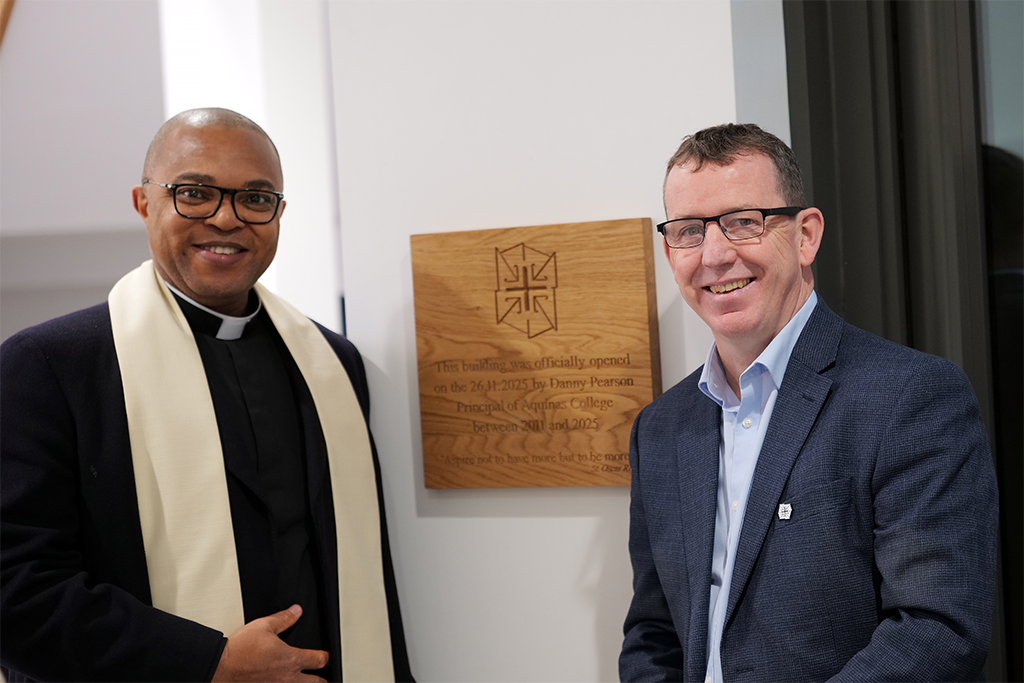 Photograph of ex principle Danny Pearson and a local priest next to the plaque.